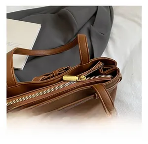Macro detail of golden metal zipper on vintage leopard print caramel leather bucket bag