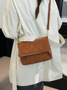 Chic caramel brown faux leather crossbody bag with fold-over flap and gold-tone zippers