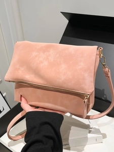 Pink matte crossbody underarm bag with gold zipper shown in a stylish hand-held pose