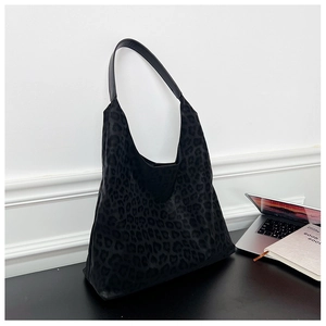 Large capacity leopard print tote bag with black leather shoulder strap on an office desk