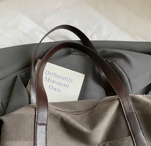 Dettaglio della borsa tote in tela marrone con manici in pelle cuciti resistenti