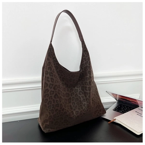 Detail of large brown leopard print tote bag with stylish suede texture on a desk