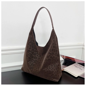 Detail of large brown leopard print tote bag with plush suede texture and laptop side