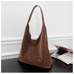 Detail of leopard print hobo tote bag with dark brown leather straps on an office desk