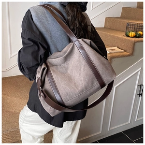 Detailed view of the large canvas tote bag with leather handles shown on a staircase