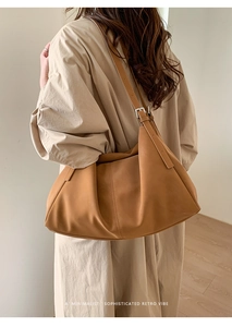 Detalle del bolso tote camel que muestra textura suave y hebilla plateada ajustable