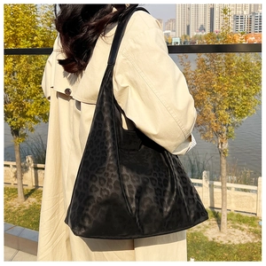 Leopard print tote bag shown on model in beige trench coat for a stylish street look