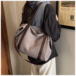 Borsa tote in tela marrone con manici in pelle indossata da modella in stile vintage