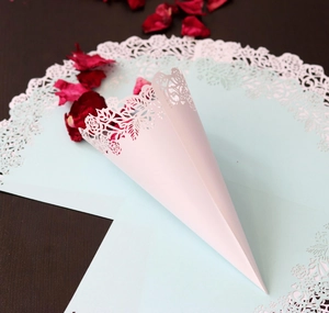Detailed laser-cut light pink paper wedding cone with intricate rose lace patterns