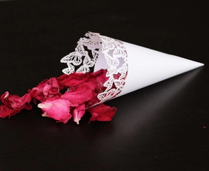 Detailed butterfly laser cut lace pattern on white wedding confetti cone with rose petals
