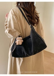 Detalle de bolso tote de ante negro con colgante de oso de peluche en vista trasera de modelo