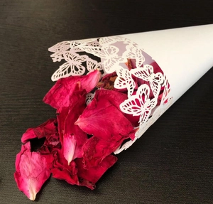 Detailed laser-cut white butterfly paper petal cone filled with dried red rose petals