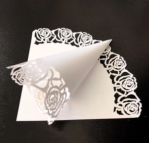 Détail d'un cône en papier blanc découpé au laser pour confettis de mariage