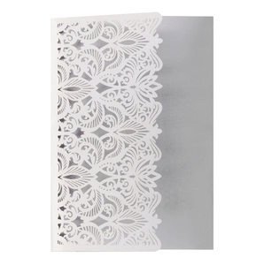 Close-up of laser cut hollow lace pattern on white wedding invitation with silver liner