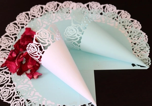Détail de cônes de mariage en dentelle découpés au laser avec motifs roses évidés