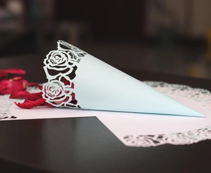 Détail du cône en papier découpé au laser rempli de pétales de fleurs séchées rouges