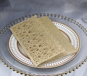 Golden laser-cut wedding invitations with glitter finish and elegant floral patterns