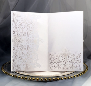 Detailed laser cut white floral patterns on elegant pearlescent paper invitation cover