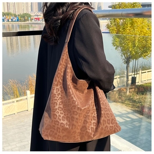 Large leopard print tote bag side view on model with natural drape in outdoor park