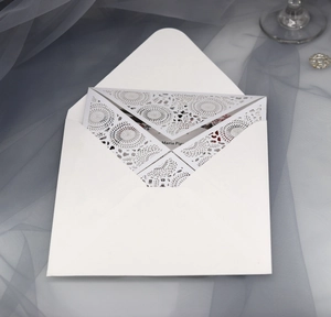 Detailed laser-cut geometric floral wedding invitation with a matching white envelope