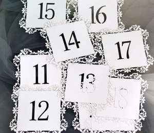 Laser-cut white wedding table numbers 11-18 with elegant hollow floral borders