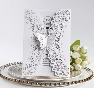 Detail of laser-cut wedding invitation with a 3D paper butterfly and floral pattern