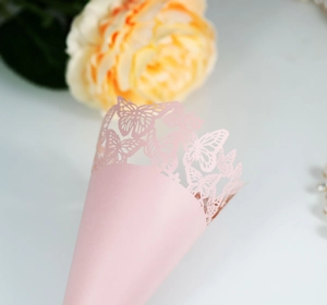 Macro detail of pink butterfly laser-cut lace cone for wedding party confetti