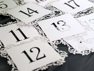 Elegant white lace table number cards with black lettering for weddings and banquets