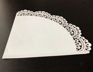 Detailed laser-cut white lace paper cone for weddings with intricate floral hollow pattern