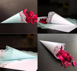 Detail of white and blue lace-cut wedding confetti cones with delicate laser-cut floral patterns