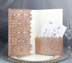 Rose gold glitter laser cut wedding invitation set with floral detail on elegant setting