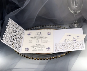 Detail of dark blue envelope invitation set with laser-cut lace and floral inner card