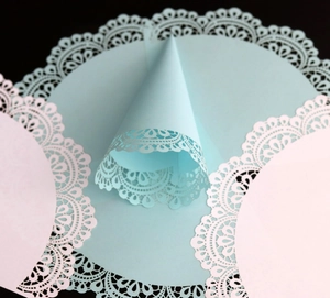 Macro shot of white and blue laser-cut lace paper cones for wedding confetti decoration