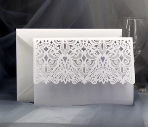 Detail view of laser-cut floral wedding invitation with inner card and envelope