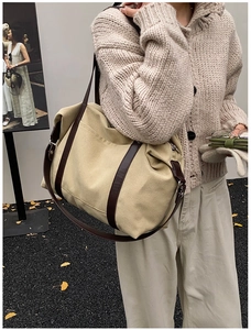 Vista dettagliata della borsa tote in tela con spalline in pelle indossata da modella