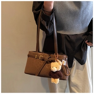 Close-up of vintage leopard bucket bag with gold buckle and teddy bear charm accessory