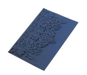 Macro view of navy blue laser-cut floral invitation with glitter texture detail