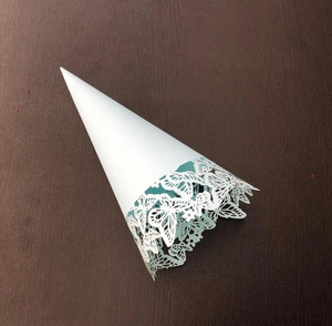 Detail of white confetti cone with laser cut butterfly pattern for wedding party events