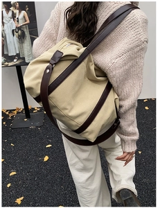 Detail showing high-density beige canvas tote with brown leather strap worn by a model