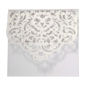 Detail of white pearlescent laser cut wedding invitation card with vintage vine pattern