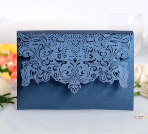 Detailed laser-cut dark blue invitation with pearlescent finish and European scroll pattern