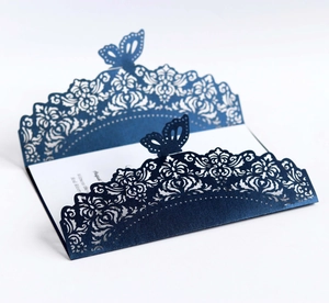 Detailed laser-cut navy blue wedding invitation with butterfly and floral patterns