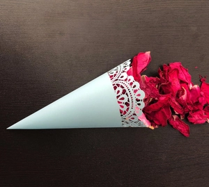 Close-up of light blue wedding confetti cone with lace trim and red rose petals