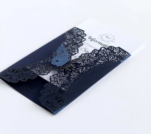 Detail of dark blue laser cut wedding invitation with elegant butterfly and floral patterns