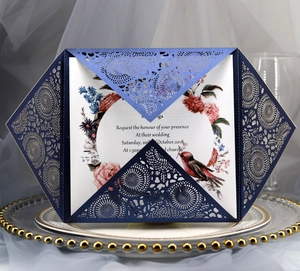 Detailed laser-cut floral wedding invitation on white porcelain plate with navy blue paper