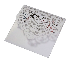 Close-up of laser cut floral lace pattern on white wedding invitation envelope