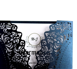 Detail of laser-cut floral pattern and pearlescent paper texture on elegant wedding invitations