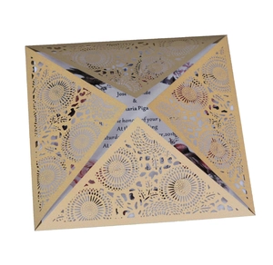 Macro detail of laser-cut invitation sleeve with champagne gold floral hollow patterns