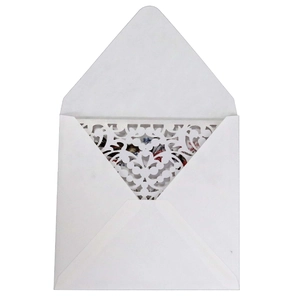 Detail of laser-cut wedding invitation card with intricate floral patterns in white paper