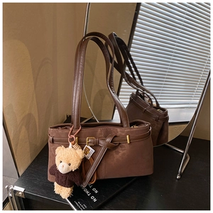 Detail of vintage brown shoulder bag with leopard lining and small bear charm